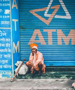 Man sitting against graffiti wall