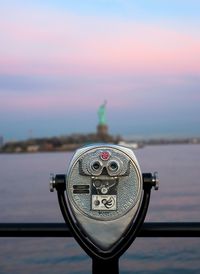 Close-up of coin-operated binoculars against cityscape