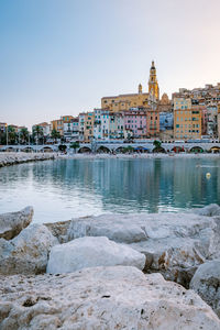 River by buildings against clear sky