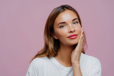 Portrait of young woman against white background