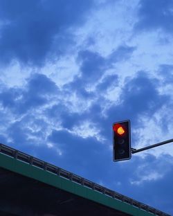 Low angle view of road sign against sky