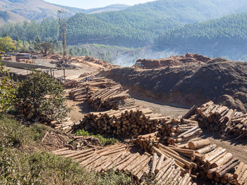 Stack of logs on landscape against mountains