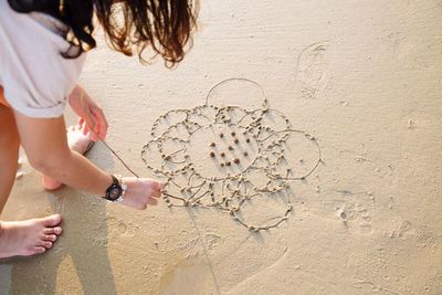 Woman drawing on beach 
