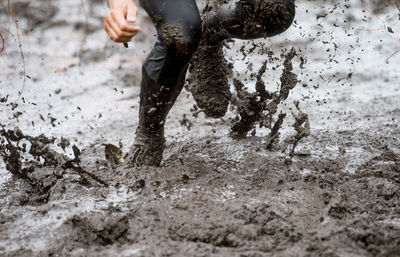 Low section of man running in mud