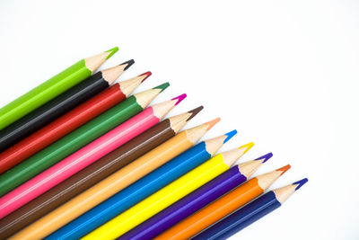 High angle view of colored pencils against white background