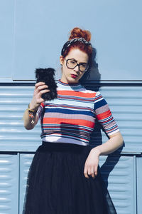 Redhead young woman taking selfie while standing against mini van