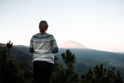 Rear view of man looking at mountain against sky