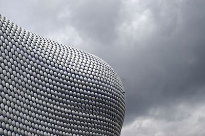 Low angle view of modern building against cloudy sky