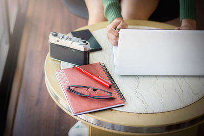 High angle view of woman reading book on table