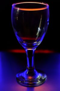 Close-up of beer glass on table against black background