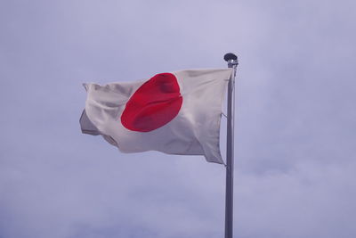 Low angle view of japanese flag against sky