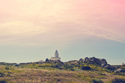 Low angle view of faro di capo testa on field at sunset