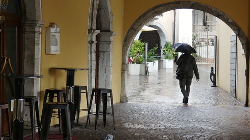 Rear view of people walking in tunnel