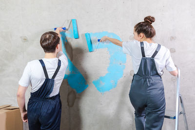 Rear view of couple standing against wall