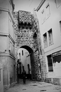 Woman standing by building in city