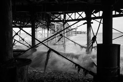 Waves rushing under pier at beach