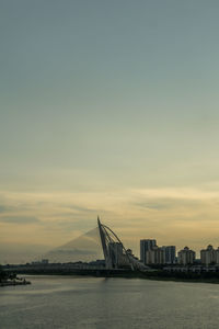 View of suspension bridge in city at sunset