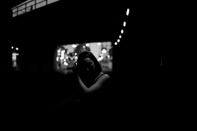 Portrait of woman photographing at night