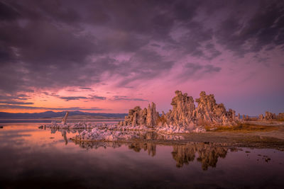 Reflection of rocks in sea against sky