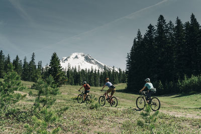 Threee women bike on a trail near mt. hood in oregon.