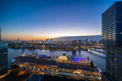 Aerial view of illuminated bridge and buildings against sky