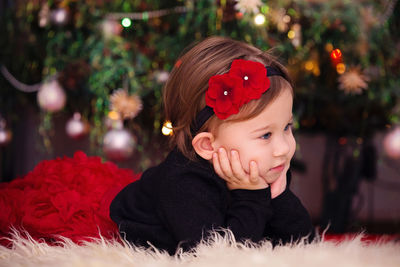 Portrait of cute boy looking away at christmas tree