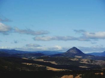 Scenic view of mountains against blue sky