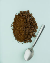 Directly above shot of coffee beans with spoon on table