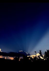 Silhouette car against blue sky at night