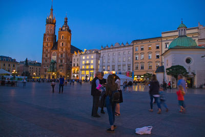 People walking in city against sky