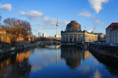 View of river by buildings against sky