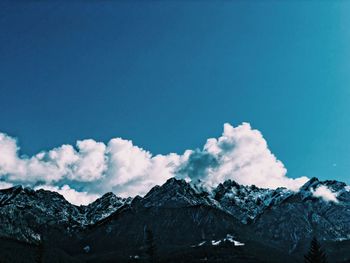 Scenic view of snowcapped mountains against blue sky