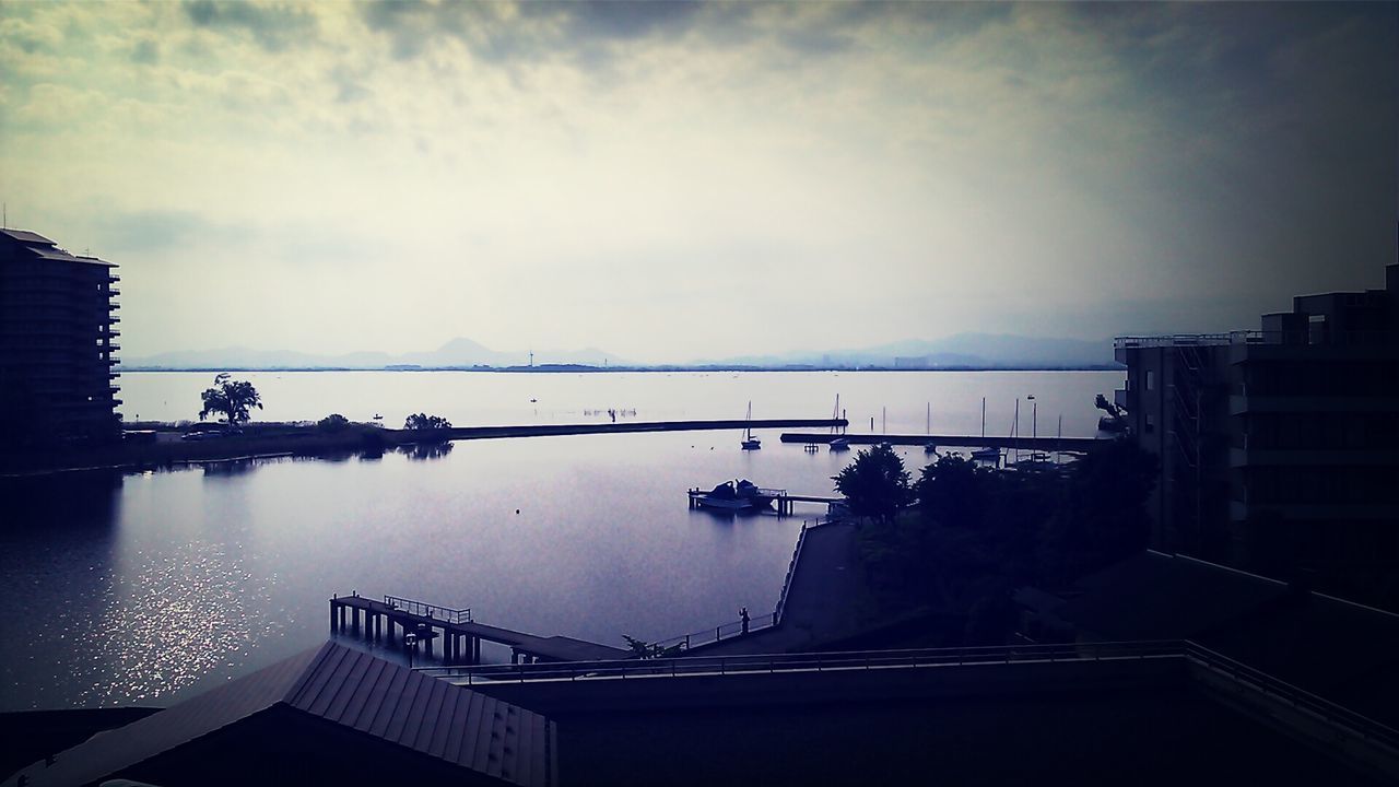 water, sky, built structure, architecture, cloud - sky, railing, transportation, building exterior, nautical vessel, sea, nature, reflection, river, mode of transport, tranquility, outdoors, beauty in nature, high angle view, scenics, tranquil scene