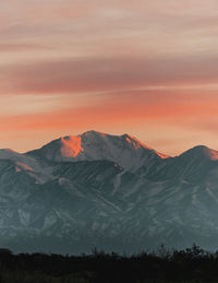 View of the snowy mountain range in the andes with the first lights of