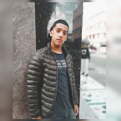 Portrait of young man standing in city