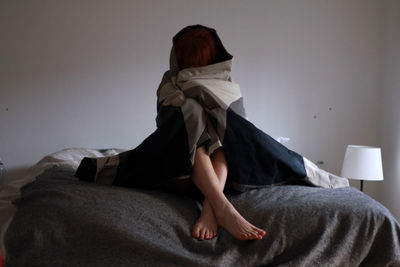 Rear view of woman sitting on sofa at home