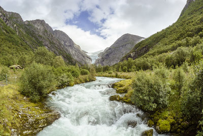 Scenic view of river amidst mountains against sky