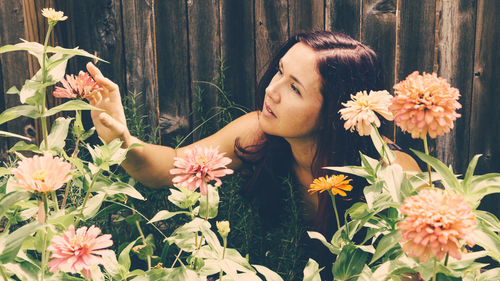 Close-up of young woman with flowers and plants