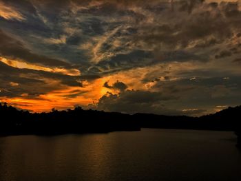 Scenic view of dramatic sky over lake during sunset