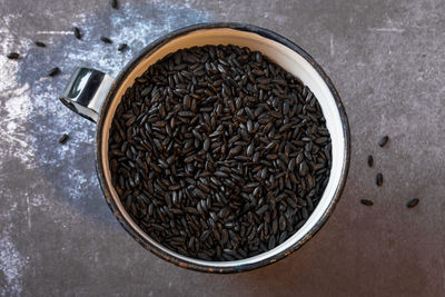 Directly above close-up of black rice in cup on table