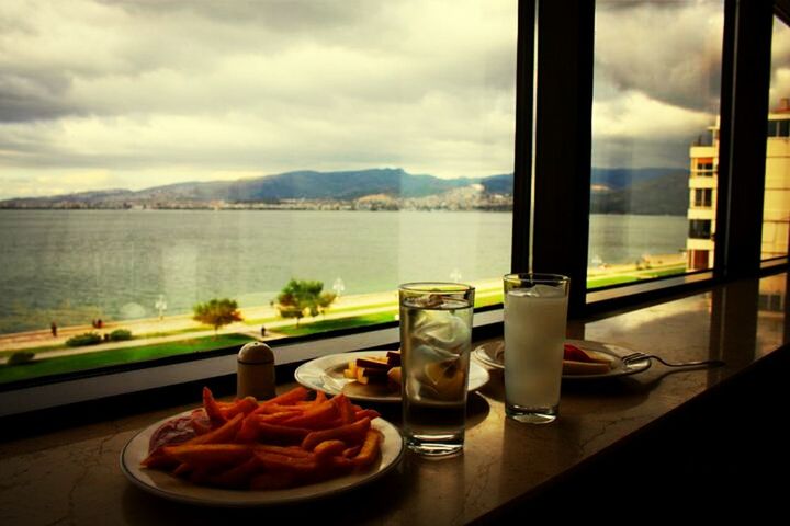 table, indoors, sky, glass - material, water, cloud - sky, window, food and drink, transparent, drink, mountain, cloud, sea, cloudy, glass, refreshment, freshness, chair, drinking glass, absence