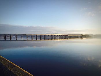 Bridge over sea against blue sky