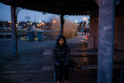 Portrait of woman sitting in city at night