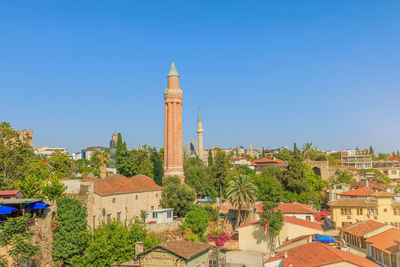 Buildings in city against clear blue sky