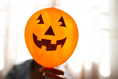 Close-up of hand holding pumpkin during halloween