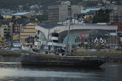 Boats in river by buildings in city