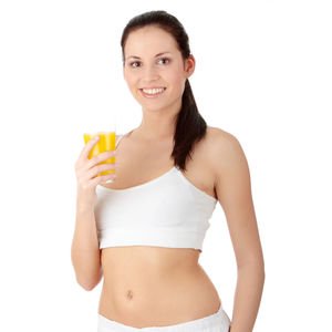 Portrait of a smiling young woman drinking glass against white background