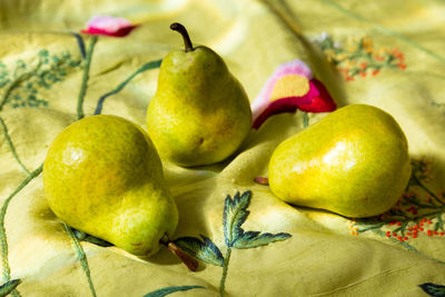 Bartlett pears on raw silk acid-green embroidered throw in soft focus background