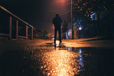 Man on illuminated street at night