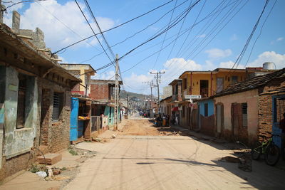 Street amidst houses against sky in city